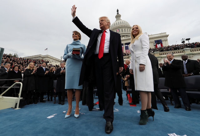 El Presidente Donald Trump saluda a la gente mientras su esposa Melania, izquierda, e hija Tiffany observan durante la ceremonia de juramentación presidencial en el capitolio, en Washington DC ,  ...