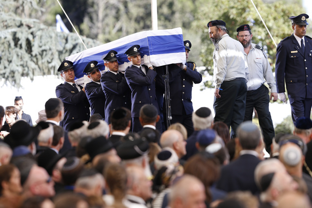 Guardias israelies Knesset cargan el cofre con los restos del lider israelí Shimon Peres, cubierto con la bandera de ese país, hacia el monte Herzel, cementerio nacional en Jerusalem, el viernes ...