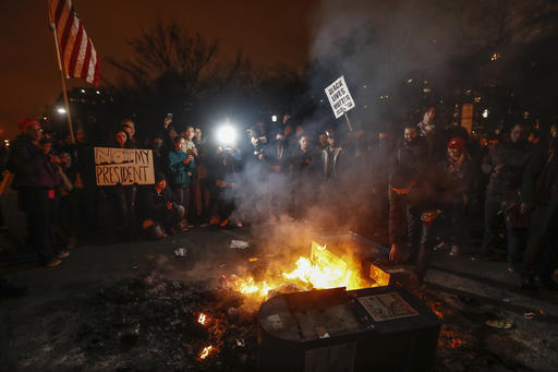 Manifestantes protestan alrededor de una fogata con desechos, luego de la ceremonia de investidura del Presidente Donald Trump, el viernes 20 de enero del 2017, en Washington. (AP Photo/John Minch ...