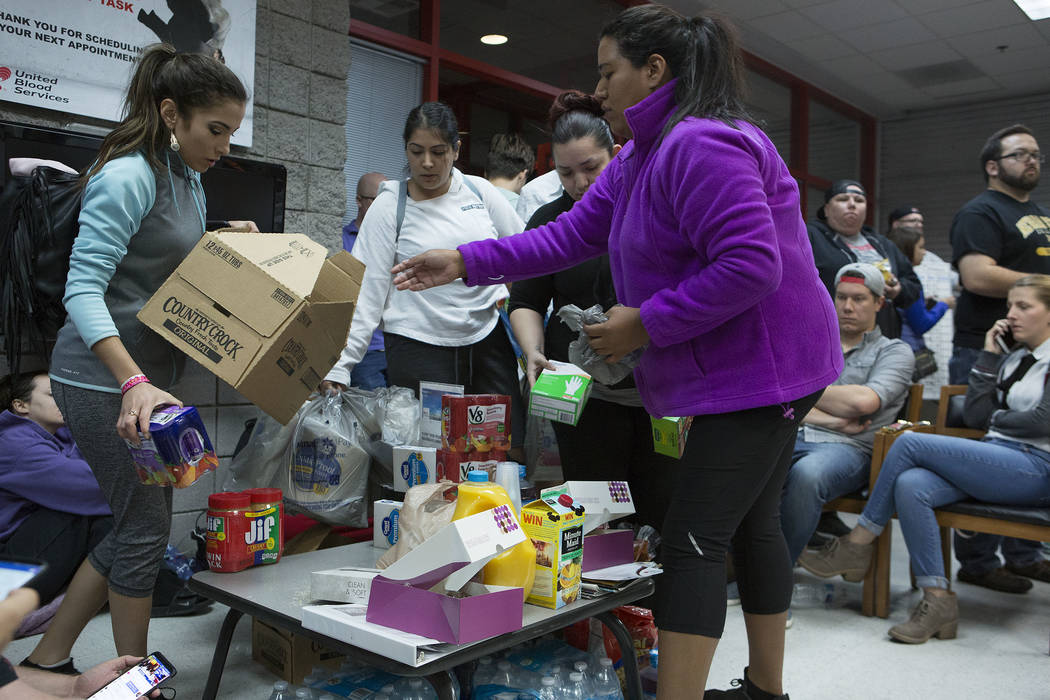 Judith González, izquierda y Emily Sandoval traen donaciones de alimentos a los que están esperando para donar sangre a United Blood Services en Las Vegas el lunes 2 de octubre de 2017, después ...