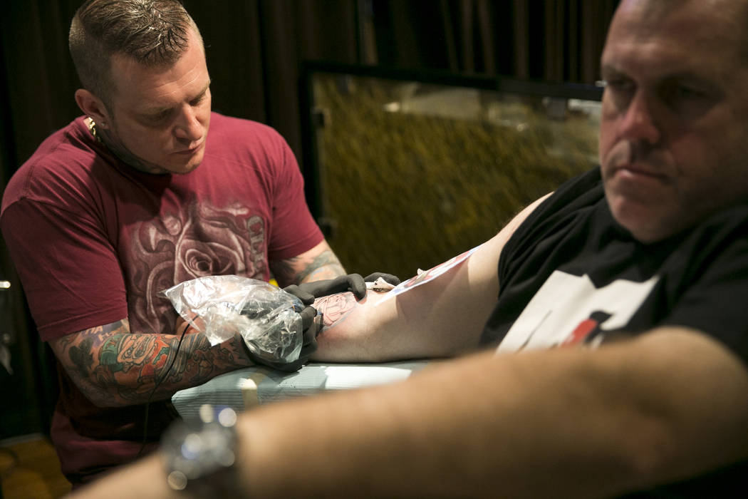 Brett Davis, a la derecha, de Australia obtiene un tatuaje conmemorativo de la Ruta 91 del artista Justin Vanbibber en Club Tattoo dentro de Planet Hollywood, el jueves 5 de octubre de 2017 en Las ...
