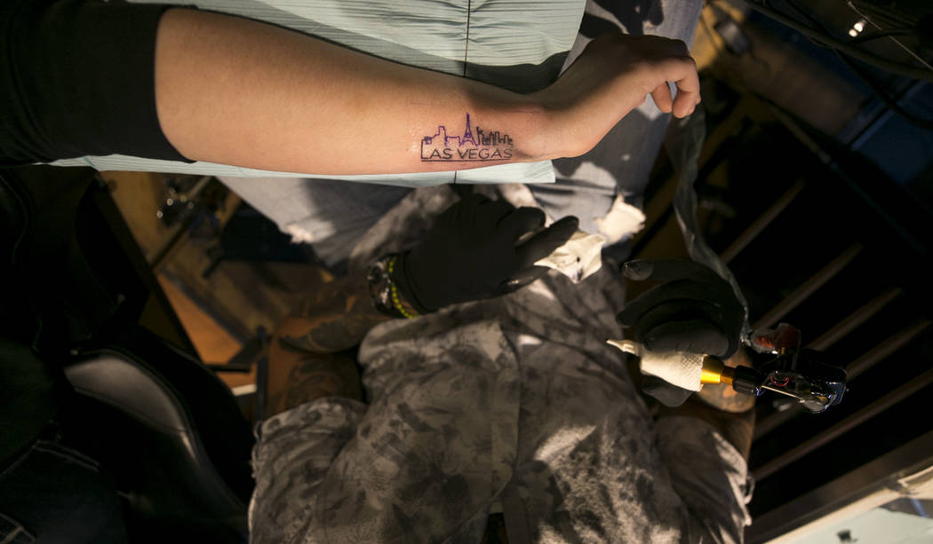La enfermera de la UCI, Devin Danner, de 25 años, de Conway, Arkansas, recibe un tatuaje conmemorativo de Las Vegas del artista José Carlos Del Campo en Club Tattoo dentro de Planet Hollywood, e ...