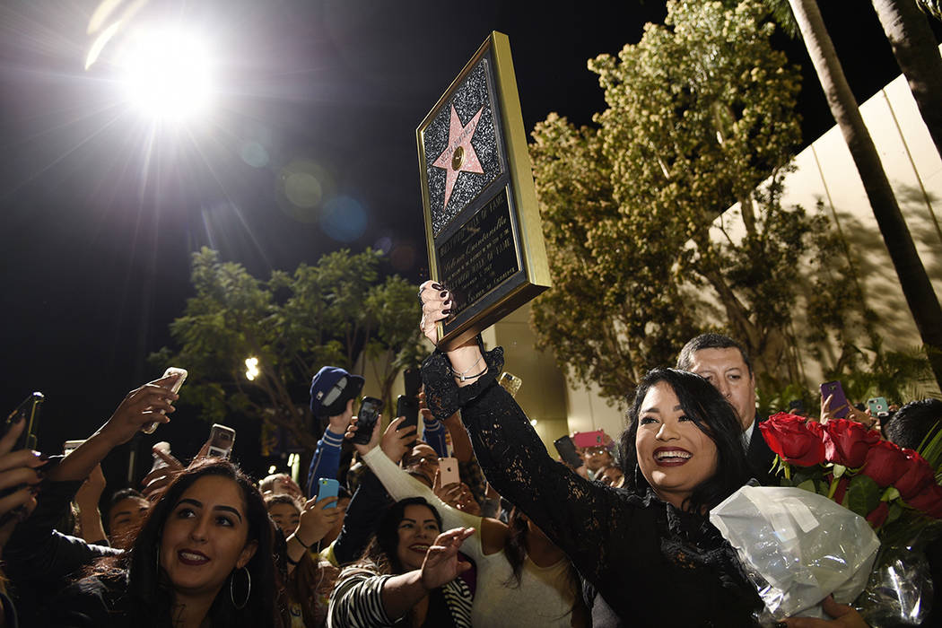 Suzette Quintanilla, hermana de la fallecida cantante Selena Quintanilla, muestra una réplica de la estrella de su hermana en el Paseo de la Fama de Hollywood a la multitud después de una ceremo ...