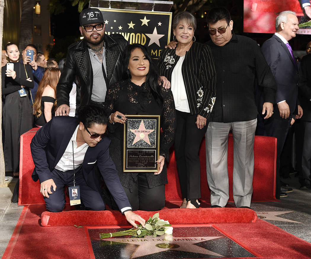 Chris Perez, abajo a la izquierda, el ex esposo de la fallecida cantante Selena Quintanilla, le pone flores a su nueva estrella en el Paseo de la Fama de Hollywood mientras posa con, de izquierda  ...