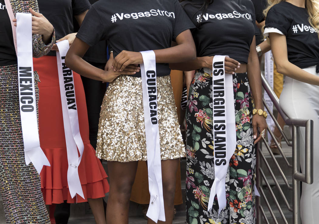 Los concursantes de Miss Universo retiran sus bandas para honrar a las víctimas del tiroteo de la Ruta 91 durante un evento de bienvenida para las concursantes en el Planet Hollywood Resort en La ...
