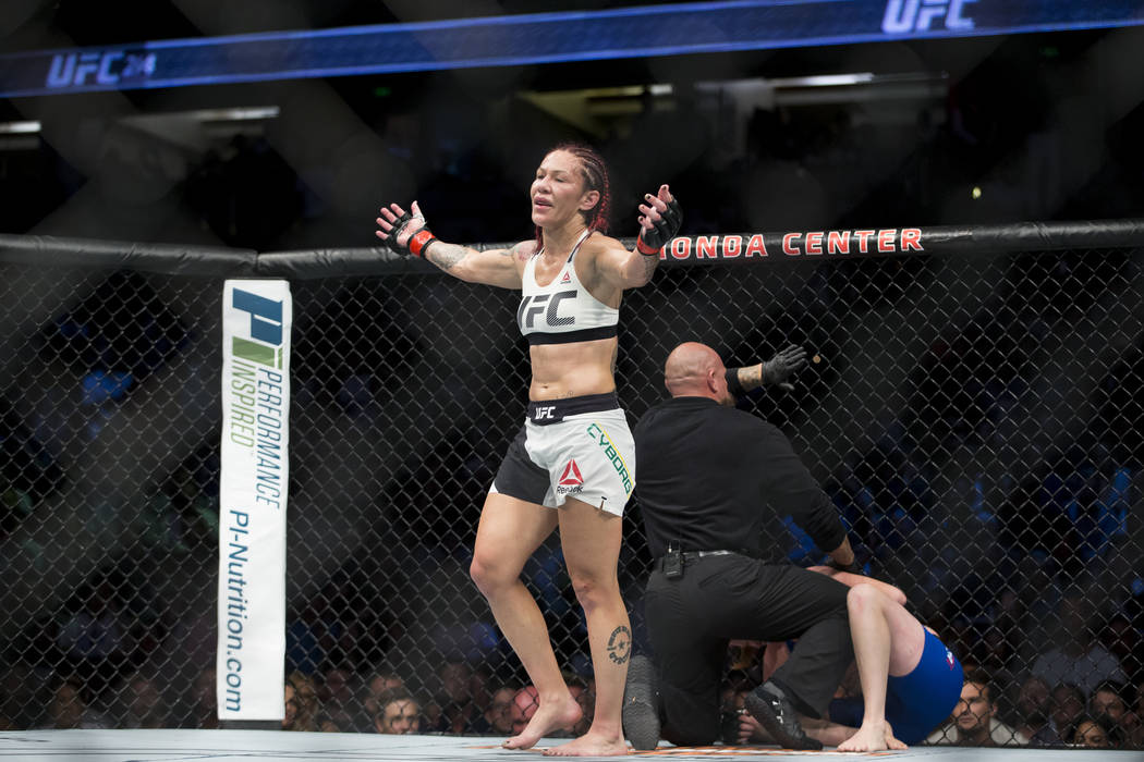 Cris "Cyborg" Justino, a la izquierda, reacciona a su victoria por nocaut técnico contra Tonya Evinger en el combate por el título pluma femenino durante el UFC 214 en el Honda Center en Anaheim ...