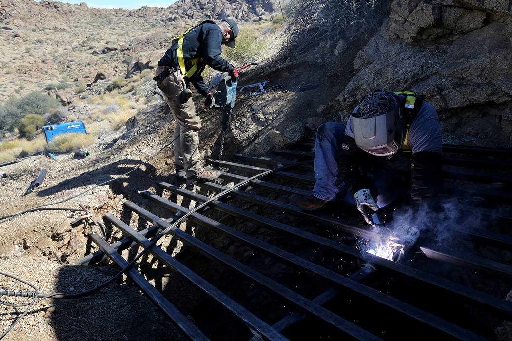 Los contratistas estatales, Brian Breiter, a la izquierda, y James Ryan aseguraron el acero a través de la apertura de una mina abandonada en el Monumento Nacional Gold Butte, el lunes 8 de octub ...
