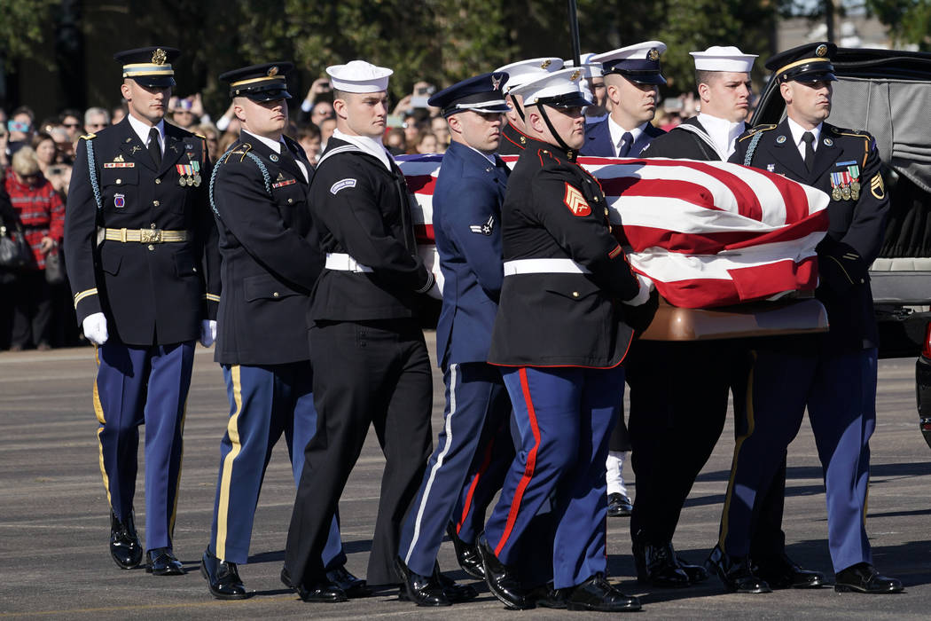 El ataúd abanderado del ex presidente George H.W. Bush es llevado por una guardia de honor militar de servicios conjuntos a la Misión Aérea Especial 41 en Ellington Field durante una ceremonia ...