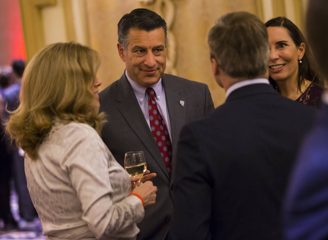 El gobernador Brian Sandoval habla junto a su esposa Lauralyn McCarthy mientras se mezcla con los invitados durante la Gala de la Ley de la UNLV en Bellagio en Las Vegas el sábado 1 de diciembre ...