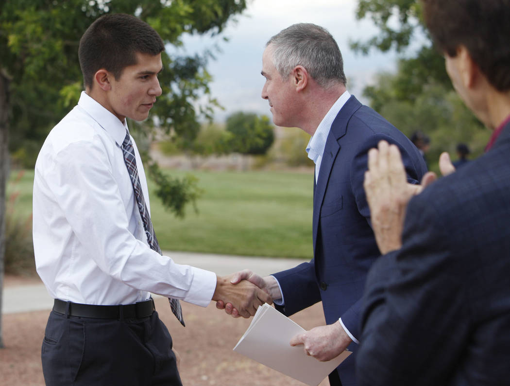 Gabriel Pence, de 17 años, le da la mano a Tom Kovach, el director ejecutivo de la Fundación ...