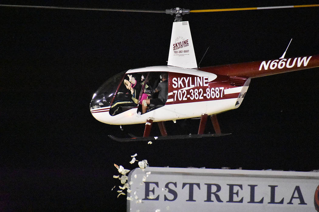 La mascota “Cash” arrojó dinero desde un helicóptero para 200 aficionados durante el medi ...