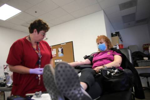 La flebotomista, Eva Clappa, izquierda, toma una donación de sangre de Susan Edwards durante u ...