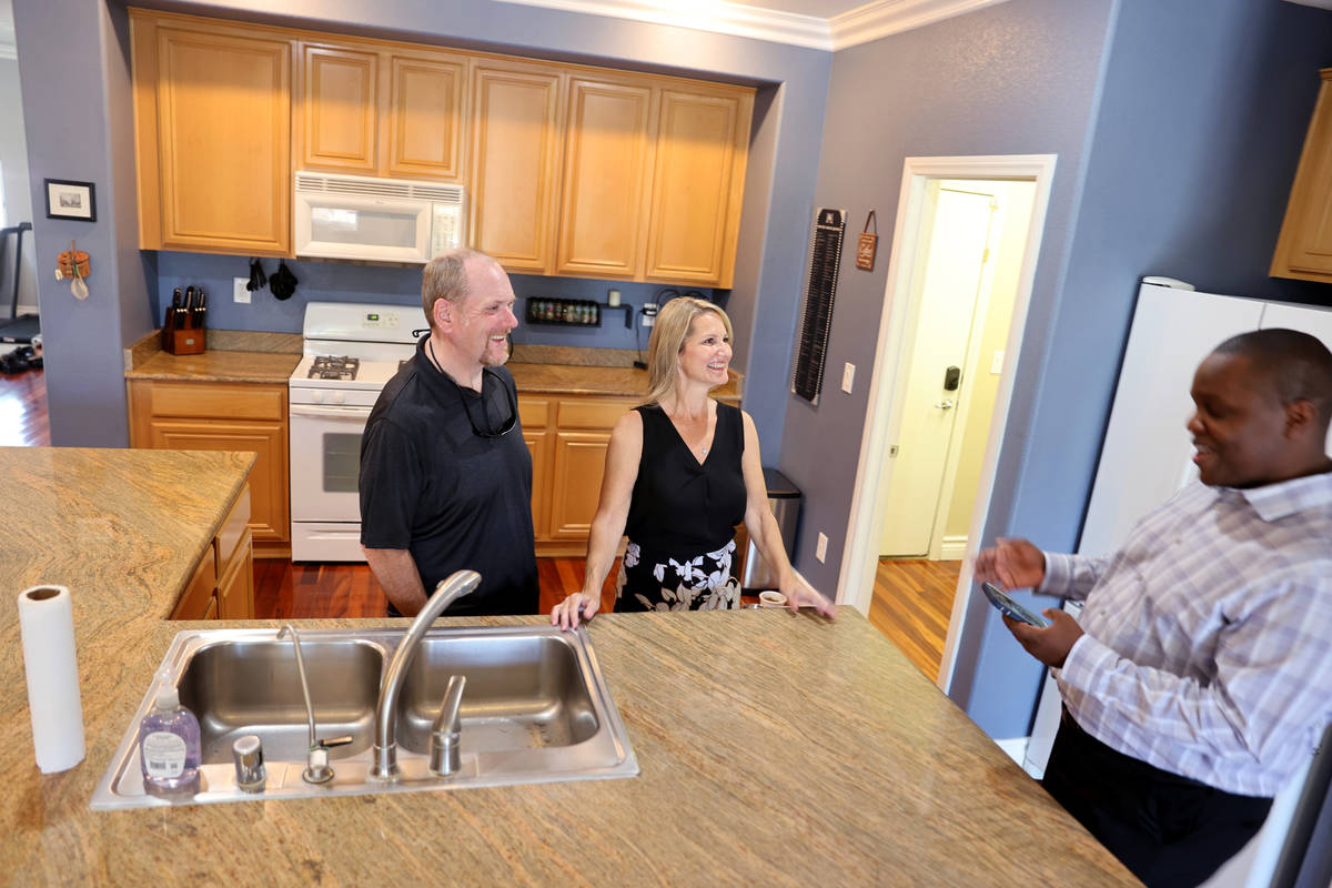 El agente inmobiliario Shawn Cunningham, a la derecha, muestra una casa en venta en Las Vegas a ...