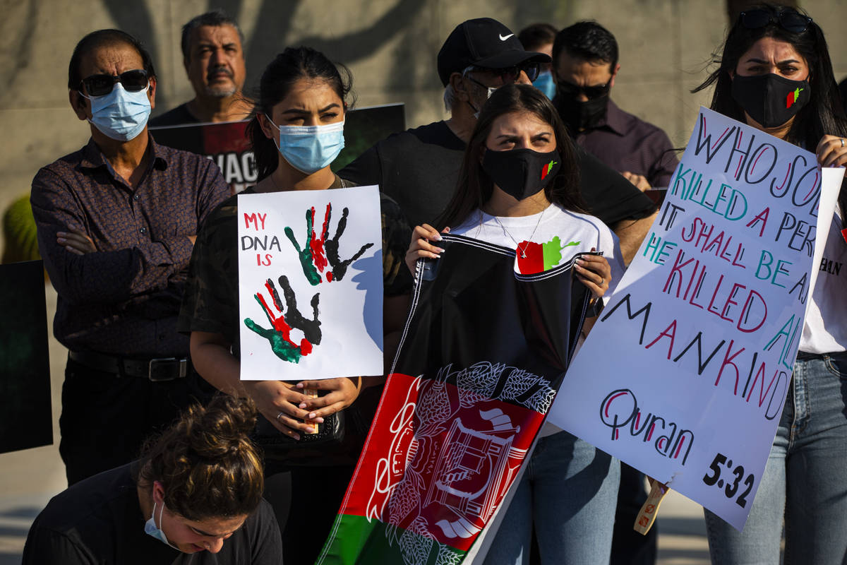 La gente sostiene carteles durante una protesta contra los talibanes y en apoyo de Afganistán ...