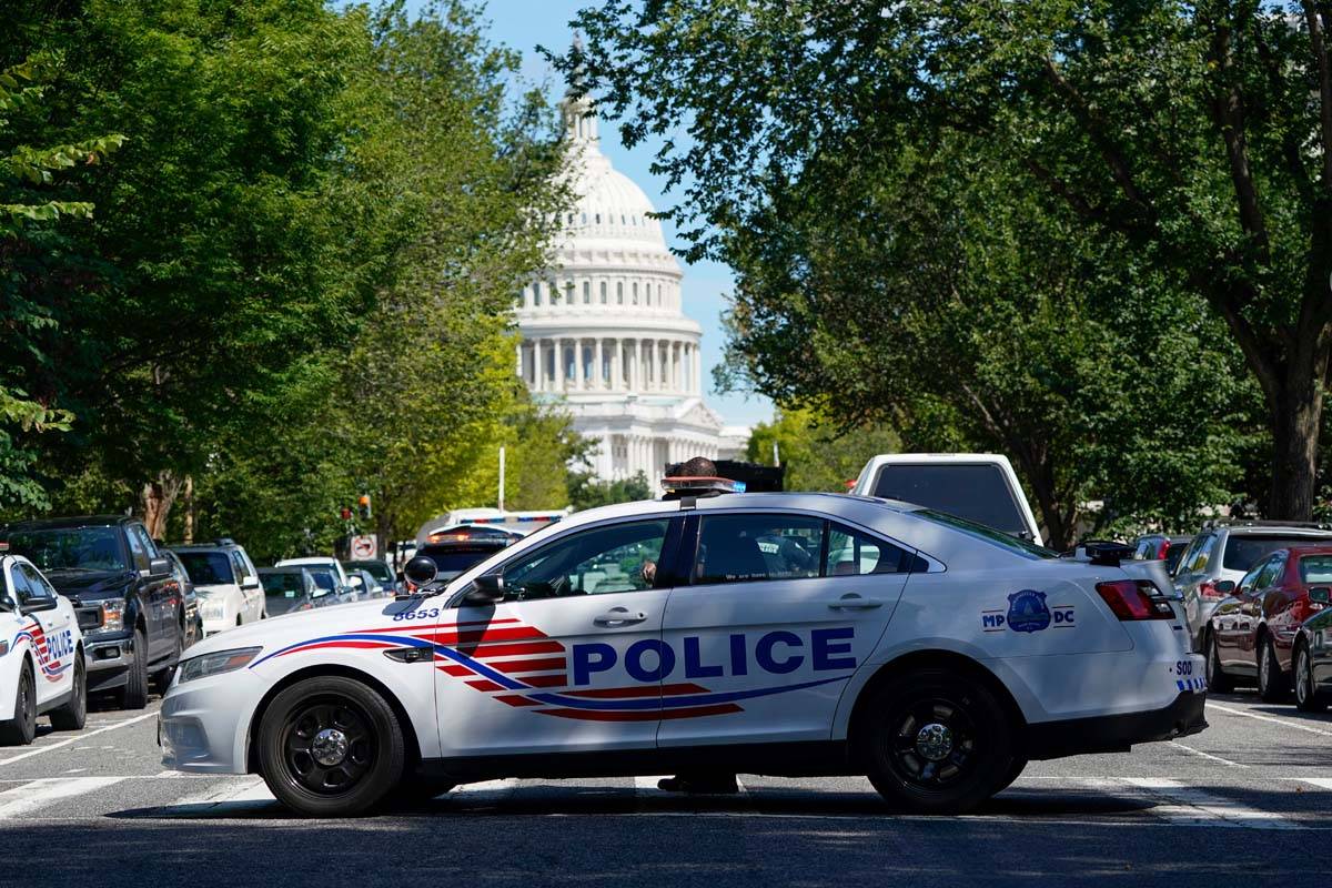 Un vehículo policial patrulla a una zona cercana al Capitolio de Estados Unidos y a un edifici ...