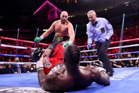 Tyson Fury, izquierda, derriba a Deontay Wilder en el tercer asalto de una pelea por el Campeon ...