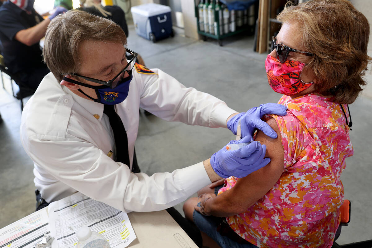 El jefe del Departamento de Bomberos del Condado Clark, John Steinbeck, entrega una vacuna COVI ...