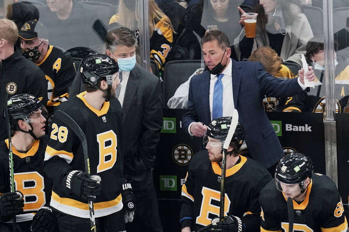 El entrenador de los Boston Bruins, Bruce Cassidy, a la derecha, habla con sus jugadores durant ...