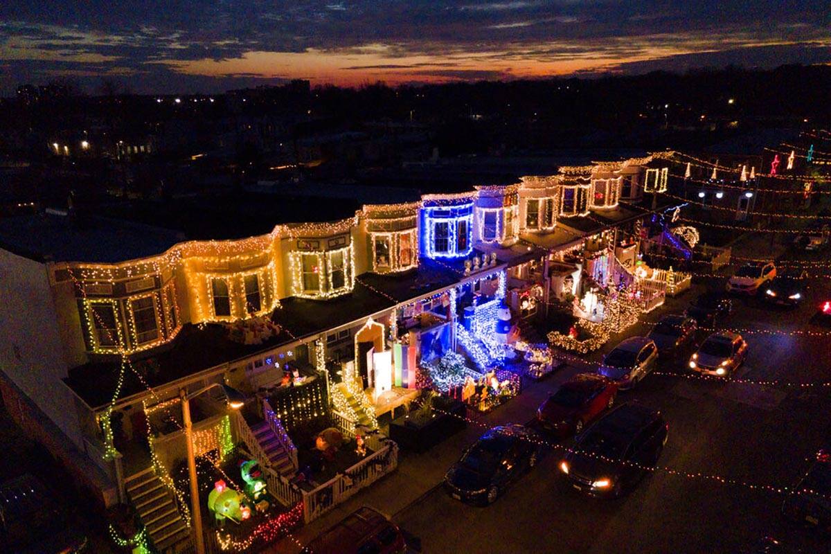 Las casas en hilera se ven cubiertas de decoraciones navideñas a lo largo del Miracle on 34th ...