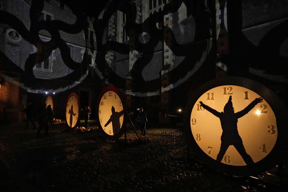 Visitantes interactúan con iluminación de relojes en el recorrido de luces "Palace of Stardus ...