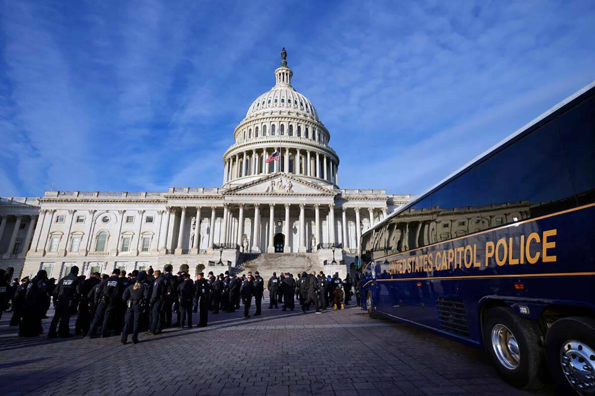 Un gran grupo de policías llega en un autobús al Capitolio, el jueves 6 de enero de 2022, en ...