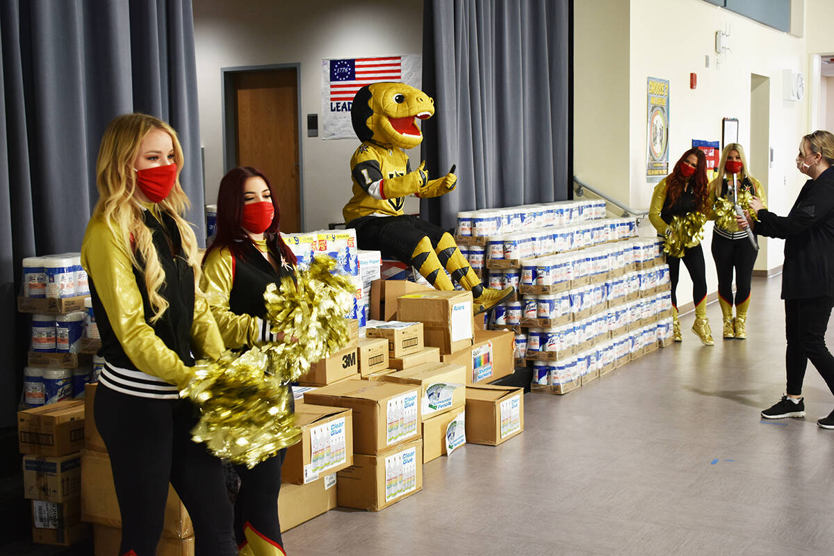 El elenco de Vegas Golden Knights muestran algunos de los suministros escolares donados a una e ...