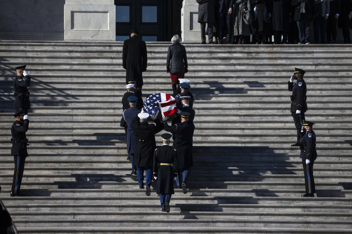 Una guardia de honor militar lleva el féretro envuelto en la bandera del ex senador Harry Reid ...